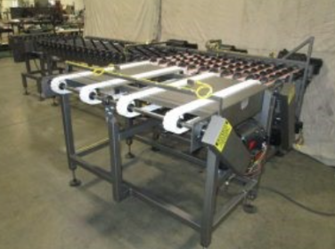 Industrial conveyor automation system with roller table and material handling components in a manufacturing facility.
